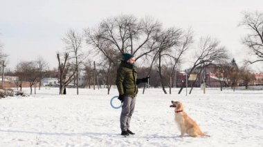 İtaatkar Golden Retriever köpeği ve sahibi kumandayı uyguluyor..