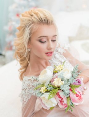 Kışın elinde bir buket çiçekle genç, güzel moda gelini. Gelin portresi, düğün makyajı ve saç stili. Lüks gelinlik içinde moda gelin modeli.