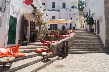 Turistler, İbiza 'da (Balear Adaları, İspanya) Dalt Vila olarak bilinen eski kentte bir kafe veya barda dinlenip içiyorlar. Şehirde hoş bir kafe..