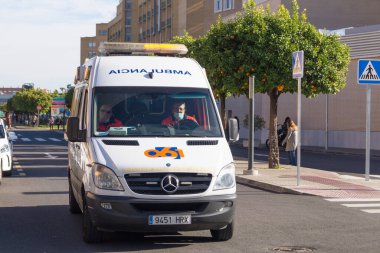 Seville 'deki Universitario Virgen del Rocio hastanesinden ayrılan iki sağlık görevlisi veya hemşirenin bulunduğu ambulans (Endülüs, İspanya).