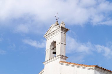 San Pedro de Aracena (Huelva, İspanya) şapelinin çan kulesi. Büyük bir çan ve bir ok ve haç şeklinde rüzgar gülü ile Hristiyan bir ibadethanenin beyaz perdesi.