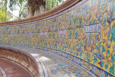 Alvarez Quintero kardeşlerin çalışmalarının onuruna renkli fayanslarla süslenmiş güzel kıvrımlı bank. Sevilla 'daki Maria Luisa Parkı' nda farklı renklerde dekore edilmiş el yapımı fayanslar (İspanya).