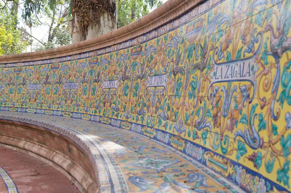 Alvarez Quintero kardeşlerin çalışmalarının onuruna renkli fayanslarla süslenmiş güzel kıvrımlı bank. Sevilla 'daki Maria Luisa Parkı' nda farklı renklerde dekore edilmiş el yapımı fayanslar (İspanya).