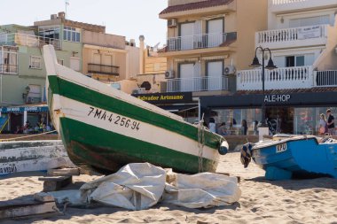 Torremolinos 'taki La Carihuela Sahili' nde (Malaga, İspanya) geleneksel ahşap balıkçı tekneleri. Kumsalın kumlarında tahta kayıklar. Güneşli bir günde Malaga 'dan gelen tekneler gezinti alanının önünde.