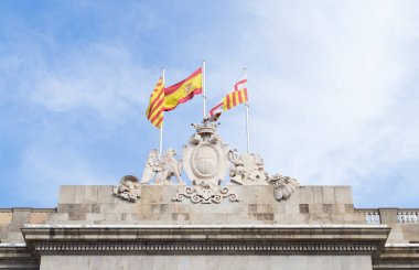 Flags of Catalonia, Spain and Barcelona flying over Barcelona City Hall. Neoclassical faade of the City Hall.