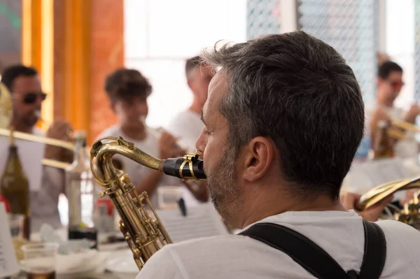 Siedzący Człowiek Grający Saksofonie Muzykami Tle — Zdjęcie stockowe