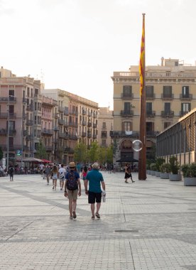 Barselona (Katalonya, İspanya) sokaklarında dolaşan şapkalı iki turist. Şehir merkezinde gezinen insanlar..