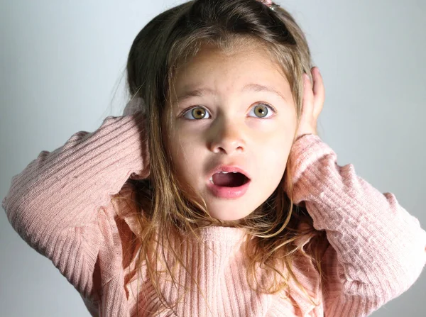 noise, stress and people concept - stressed young child closing ears by hands