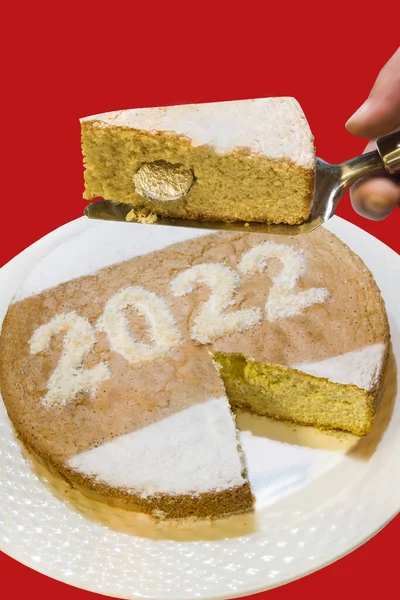 Greek New Year pice of cake with lucky coin with red background. Vasilopita 2022. 