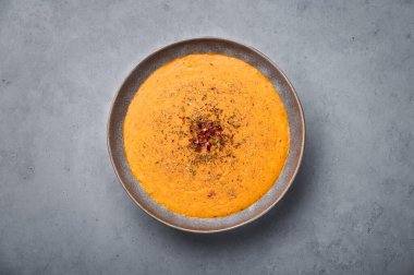 Ezogelin Soup in gray bowl on concrete table top. Turkish cuisine traditional dish with red lentils, bulgur and rice