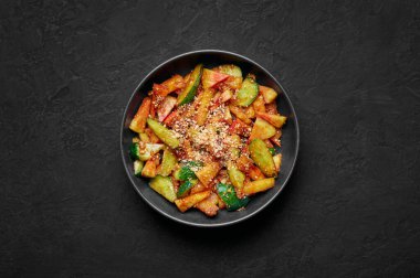Penang Rojak in black bowl on dark slate table top. Malaysian or indonesian cuisine fruits and vegetables salad dish. Asian Food. Top view