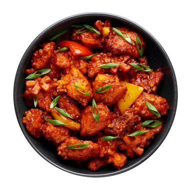 Fish Manchurian dry looks like Schezwan Fish in black bowl isolated on white background. Fish Manchurian - is indo chinese cuisine dish with deep fried salmon, bell peppers, sauce and onion. Top view.
