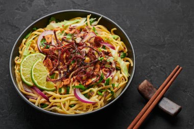 Burmese Atho in black bowl on dark slate table top. Atho is myanmar indian cuisine dish popular in Chennai. Asian food and meal.