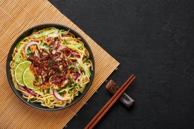 Burmese Atho in black bowl on dark slate table top. Atho is myanmar indian cuisine dish popular in Chennai. Asian food and meal. Top view. Copy space