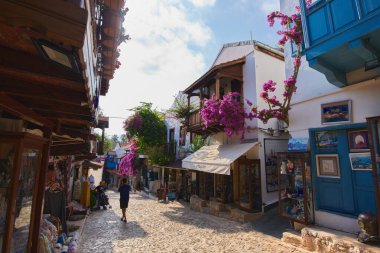 Kas, Turkey - 08 June 2022. Kas town cozy street. Overgrown with flowers Turkish village blooming street. Shop in Kas