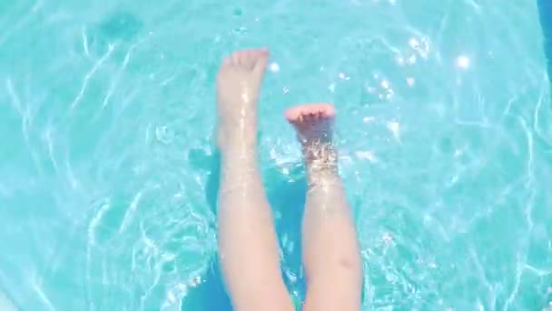 プールで足で遊んでいる子供はプールで泳ぐ夏休み青い水のスプラッシュは泳ぐことを学ぶ — ストック動画