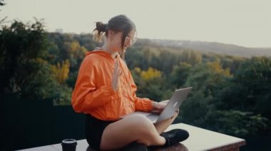 İyimser ve çekici olan genç öğrenci, üniversite uygulaması hakkında bir video konferansına katılıyor. Onları gülümseyerek selamladı, elini salladı. Turuncu bir bluz giymişti, saçları sıkışmıştı.