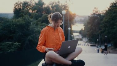 Hırslı genç kadın yeni bir dizüstü bilgisayar şirketi için çalışıyor, telefonu çalıyor, cevap veriyor ve iyimser konuşuyor. Parlak turuncu bir bluz giymişti. Saçları topuz şeklindeydi. Lotus pozisyonundaydı.