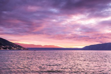 Arnavutluk 'ta gün batımında bulutlu deniz manzarası.