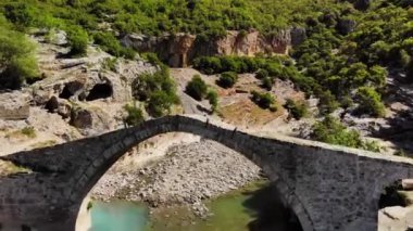 Arnavutluk 'ta antik bir kemerli, taş köprünün altında uçuyor