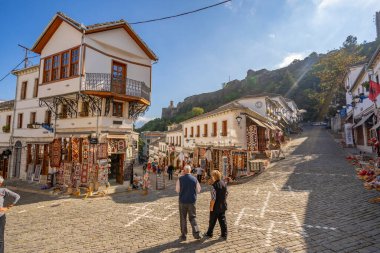 GJIROKASTER, ALBANIA - Haziran 07, 2021: Gjirokaster, Arnavutluk 'un tarihi kenti Cirokasteron' un merkezinde kimliği belirlenemeyen bir sokak sahnesinde yerel halk. UNESCO 'nun Dünya Mirası Sitesi