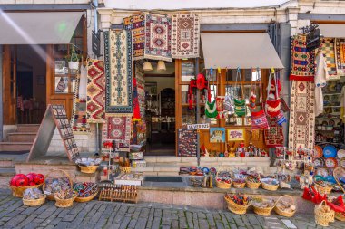 GJIROKASTER, ALBANIA - Haziran 07, 2021: Gjirokaster, Arnavutluk 'un tarihi kenti Cirokasteron' un merkezinde kimliği belirlenemeyen bir sokak sahnesinde yerel halk. UNESCO 'nun Dünya Mirası Sitesi