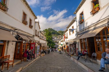 GJIROKASTER, ALBANIA - Haziran 07, 2021: Gjirokaster, Arnavutluk 'un tarihi kenti Cirokasteron' un merkezinde kimliği belirlenemeyen bir sokak sahnesinde yerel halk. UNESCO 'nun Dünya Mirası Sitesi