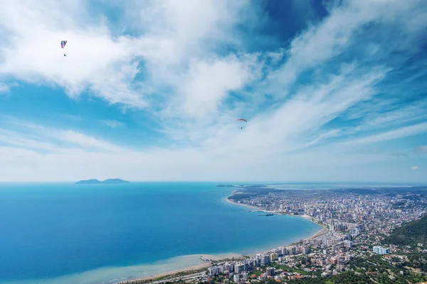 Athlete paragliding against the backdrop of a cloudy sky over the city on a summer day. Albania — Stockfoto