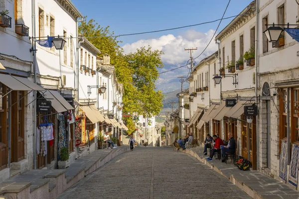 GJIROKASTER, ALBANIA - Haziran 07, 2021: Gjirokaster, Arnavutluk 'un tarihi kenti Cirokasteron' un merkezinde kimliği belirlenemeyen bir sokak sahnesinde yerel halk. UNESCO 'nun Dünya Mirası Sitesi