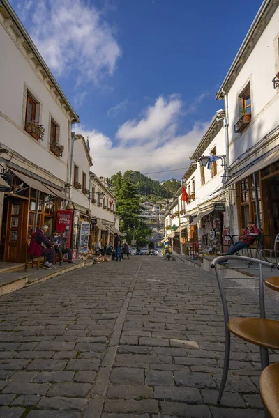 GJIROKASTER, ALBANIA - Haziran 07, 2021: Gjirokaster, Arnavutluk 'un tarihi kenti Cirokasteron' un merkezinde kimliği belirlenemeyen bir sokak sahnesinde yerel halk. UNESCO 'nun Dünya Mirası Sitesi.