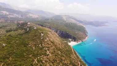 Gjipe Sahili ve Kanyonu Hava Aracı Manzarası, Dhermi, Arnavutluk - Tekneler, turistler, güneşlikler ve mavi denizle Saklı Paravan.