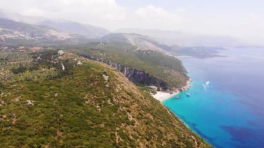 Gjipe Sahili ve Kanyonu Hava Aracı Manzarası, Dhermi, Arnavutluk - Tekneler, turistler, güneşlikler ve mavi denizle Saklı Paravan.