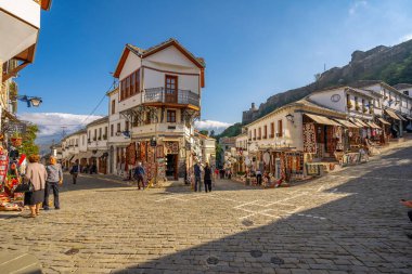 GJIROKASTER, ALBANIA - Haziran 07, 2021: Gjirokaster, Arnavutluk 'un tarihi kenti Cirokasteron' un merkezinde kimliği belirlenemeyen bir sokak sahnesinde yerel halk. UNESCO 'nun Dünya Mirası Sitesi.