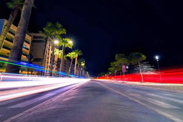 Long exposure with vehicle light streaks at night on the harbor by the sea in Vloe, Albania.