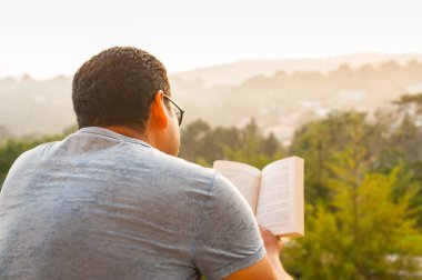 Man enjoy reading outdoors, man on terrace with a book