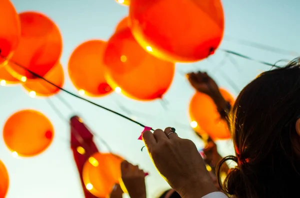 People Releasing Orange Balloons Blue Sky — Foto Stock