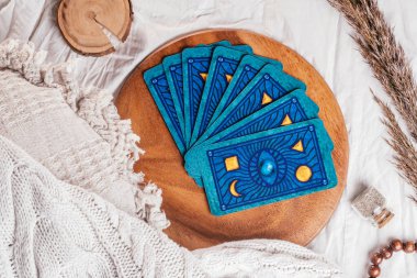 Güverte Tarot kartları ahşap tepside, yastıklı, yatak örtülü ve dikenli beyaz kumaş çarşaflarda seriliydi. Üst Manzara. Minsk, Belarus - 09.27.2021