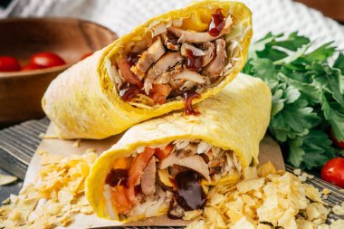 Patates kızartması, barbekü sosu, tavuk ve sebzeler ahşap arka planda, kiraz domatesli ve yeşil maydanozlu pide.