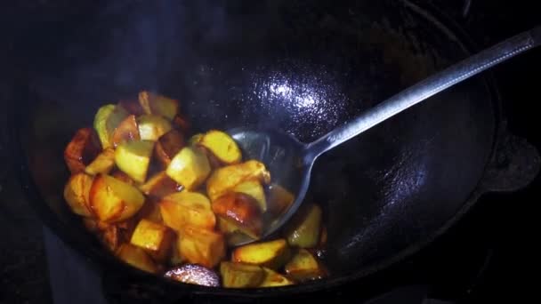 Patatas preparadas en caldero de calle. Movimiento lento revolviendo papas crujientes mientras se prepara ajapsandali. plato de cocina georgiana — Vídeo de stock