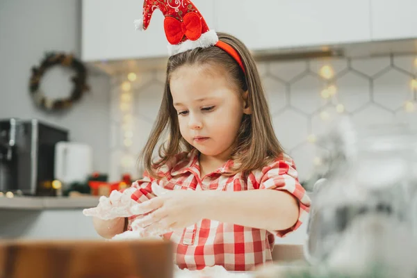 크리스마스 모자를 체크무늬 셔츠를 살난작은 머리의 아이가 화환으로 장식된 크리스마스 — 스톡 사진