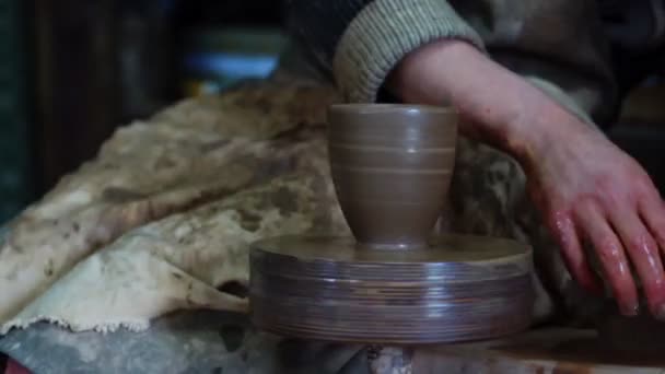 Ruce hrnčíře vyrábějící hliněný hrnec na ručním hrnčířském kole s pohonem nohou. Výroba řemeslné keramiky — Stock video