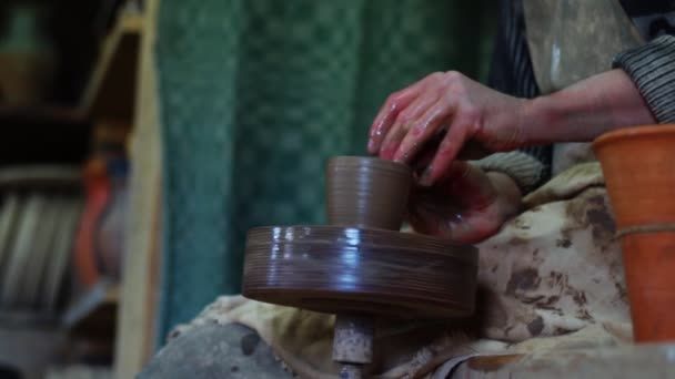 Mãos de oleiro fazendo panela de barro na roda de oleiros manual com pé drive. Fabricação de cerâmica artesanal. Movimento lento — Vídeo de Stock
