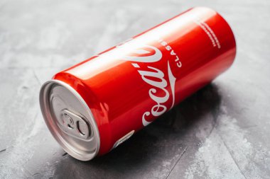 Kırmızı metal Coca-Cola kutusu gri beton yüzeyde yatıyor. Minsk, Belarus, 12.11.2021