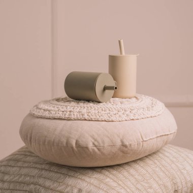 Silikon bebek bulaşıkları. İki bej renkli bardakta pipet örülmüş yastıklar. Yaratıcı bulanıklık ve tahıl. Kare kare