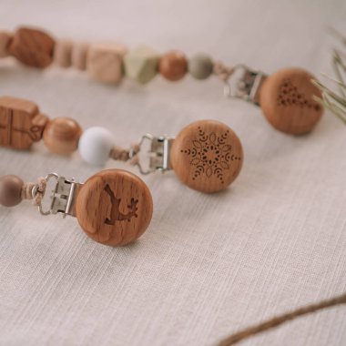 Üç Noel ahşap emziği, üzerinde silikon boncuklar ve masa örtüsü olan bir oyma. Yaratıcı bulanıklık