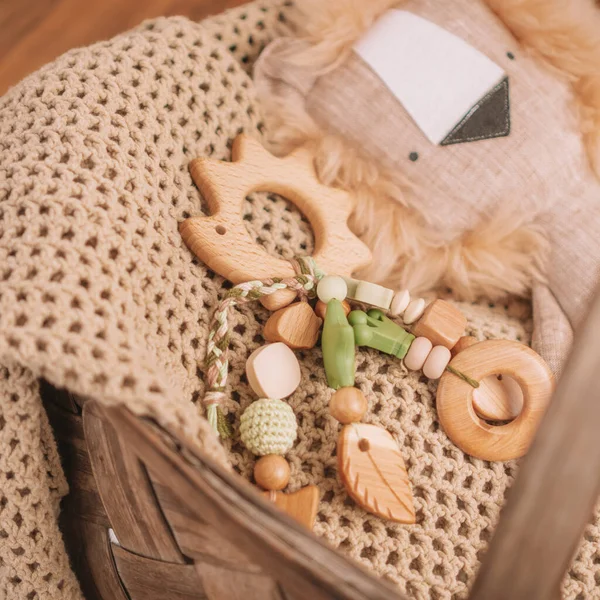 Dřevěný dětský ježek ve tvaru ježka se silikonovými korálky na béžové přikrývce v košíku s měkkou hračkou. Čtvercový — Stock fotografie