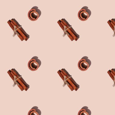 Kusursuz, sert gölgeli, açık pembe arka planda izole edilmiş tarçın deseni. Üst görünüm