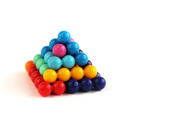 Tetragonal pyramid of multi-colored puzzle elements in the form of balls, isolated — Stock Photo, Image