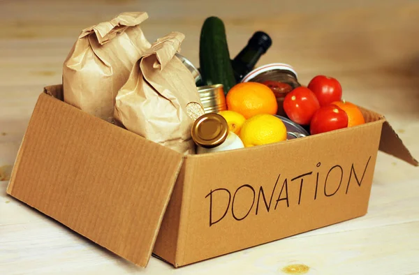 Various food in a cardboard donation box — Fotografia de Stock