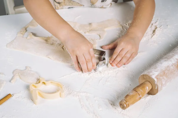 Обрізане фото маленьких дитячих рук, вирізане тісто для тіста металевою чашкою. Скульптурне тісто борошняне печиво — стокове фото